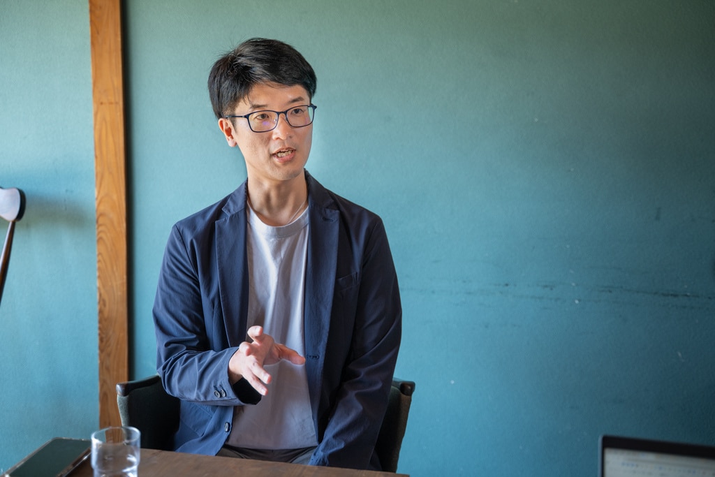 身振り手振りを交えながら、非エンジニアとしてAI活用へ踏み出したきっかけを語る畠山謙人氏