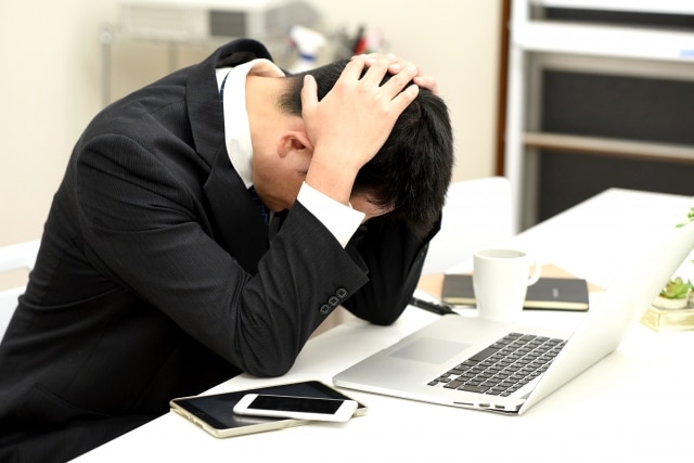 オフィスで頭を抱える会社員