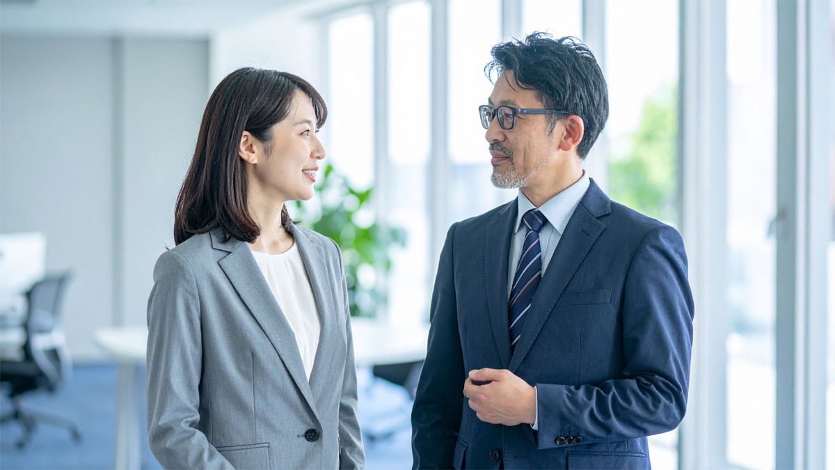 職場で上司と部下が対話する様子。相手を尊重しながら自分の意見を適切に伝えるアサーティブコミュニケーションの実践を示すイメージ
