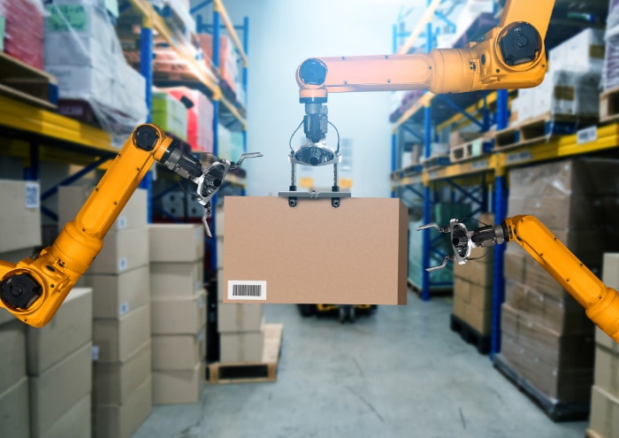 倉庫でダンボール箱を持ち上げるロボットアーム