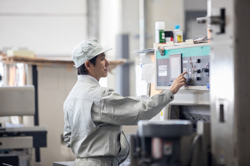 製造ラインで機械の設定を確認する作業者