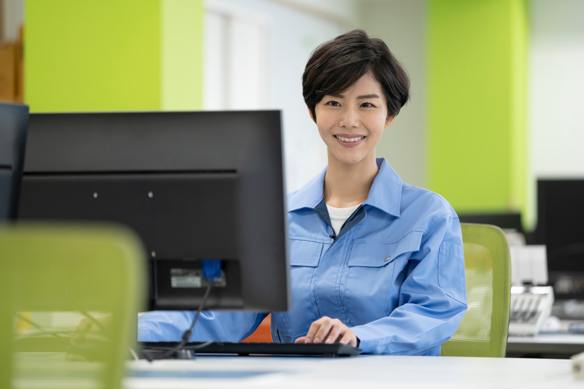 デスクワーク　作業服の若い女性
